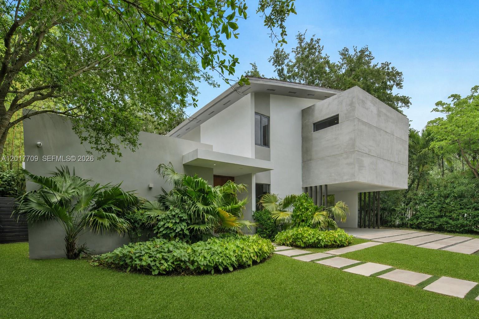 A modern two-story house features concrete walls, a flat roof, and a landscaped front yard — 10 Samana Dr, Miami FL 33133, MIAMI, FL