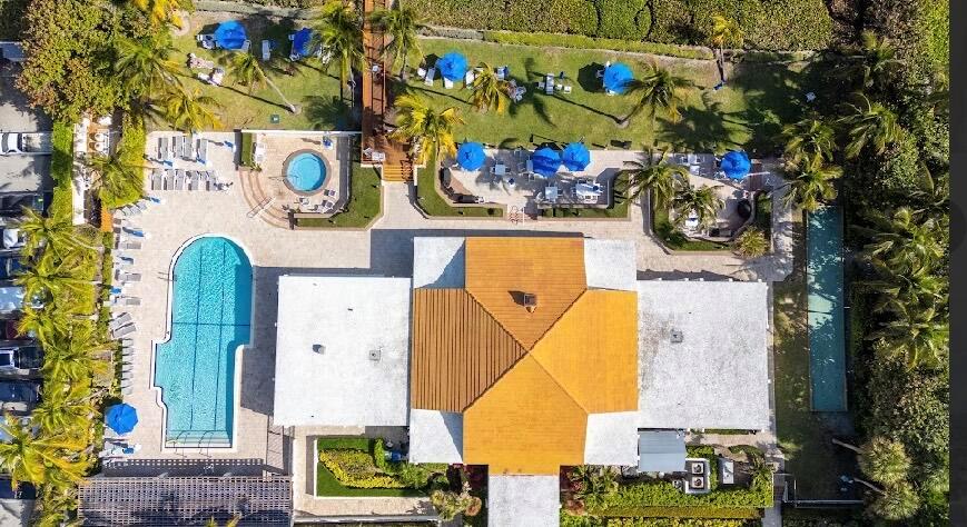 Aerial view of a building with a pool, hot tub, and patio area with umbrellas — 3400 S Ocean Boulevard, Highland Beach FL 33487, HIGHLAND BEACH, FL