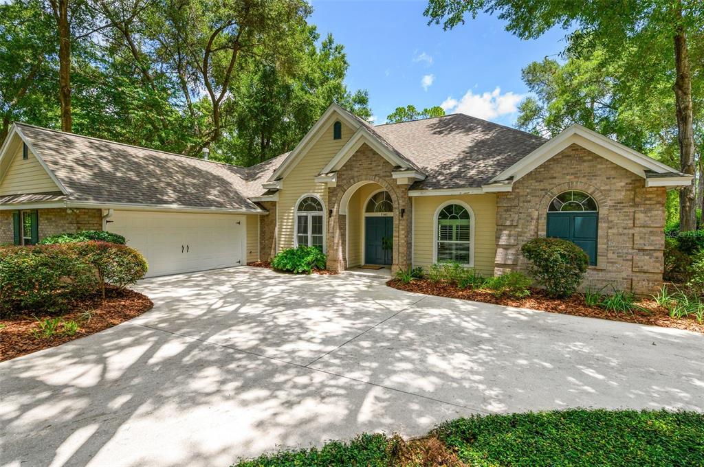 A single-story house with a beige siding, stone facade, and a concrete driveway — 9340 SW 32ND PLACE, GAINESVILLE, FL