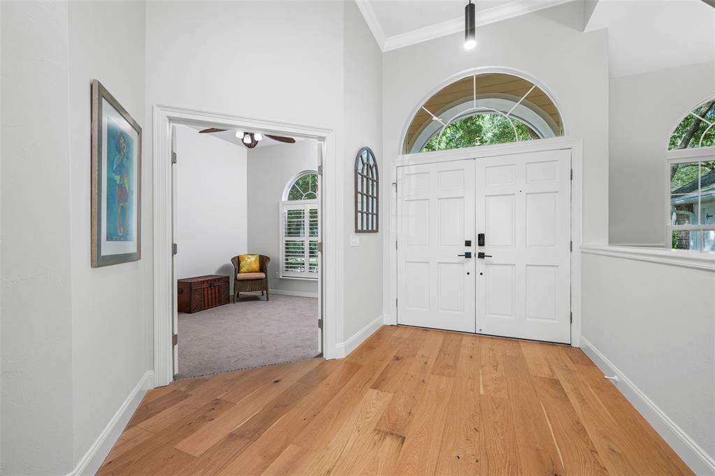 An entryway features light wood flooring, double white doors, and an arched transom window — 9340 SW 32ND PLACE, GAINESVILLE, FL