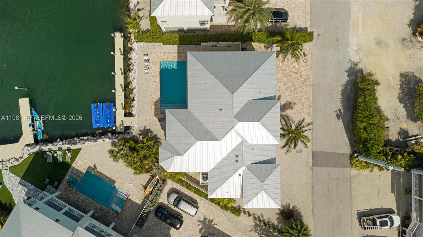 An aerial view shows a house with a metal roof, swimming pool, and private dock — 865 50th Street Gulf, Marathon FL 33050, MARATHON, FL
