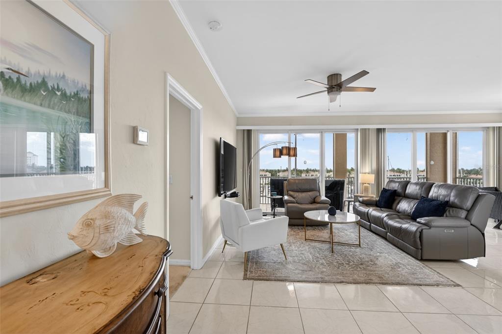 A living room features tile floors, a gray leather sofa, and a balcony with views — 2060 MATECUMBE KEY ROAD UNIT 2506, PUNTA GORDA, FL