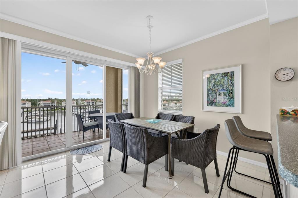 A dining area with a table, six chairs, a chandelier, and a balcony overlooking water — 2060 MATECUMBE KEY ROAD UNIT 2506, PUNTA GORDA, FL