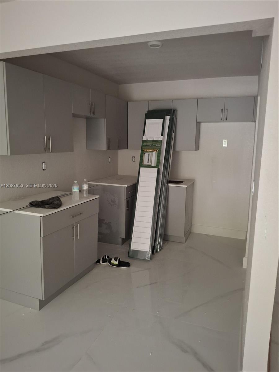A kitchen under renovation features gray cabinets, white countertops, and light-colored tile flooring — 13480 NE 6th Ave # 207, North Miami FL 33161, NORTH MIAMI, FL