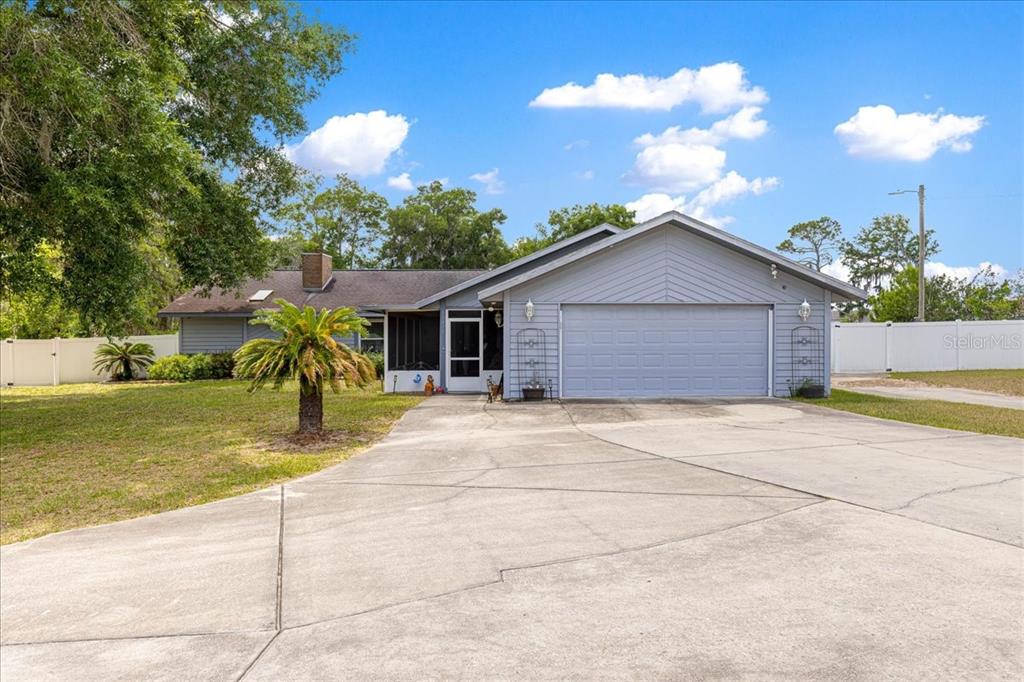 A single-story house with gray siding, a two-car garage, and a concrete driveway — 11470 SE 73RD COURT, BELLEVIEW, FL