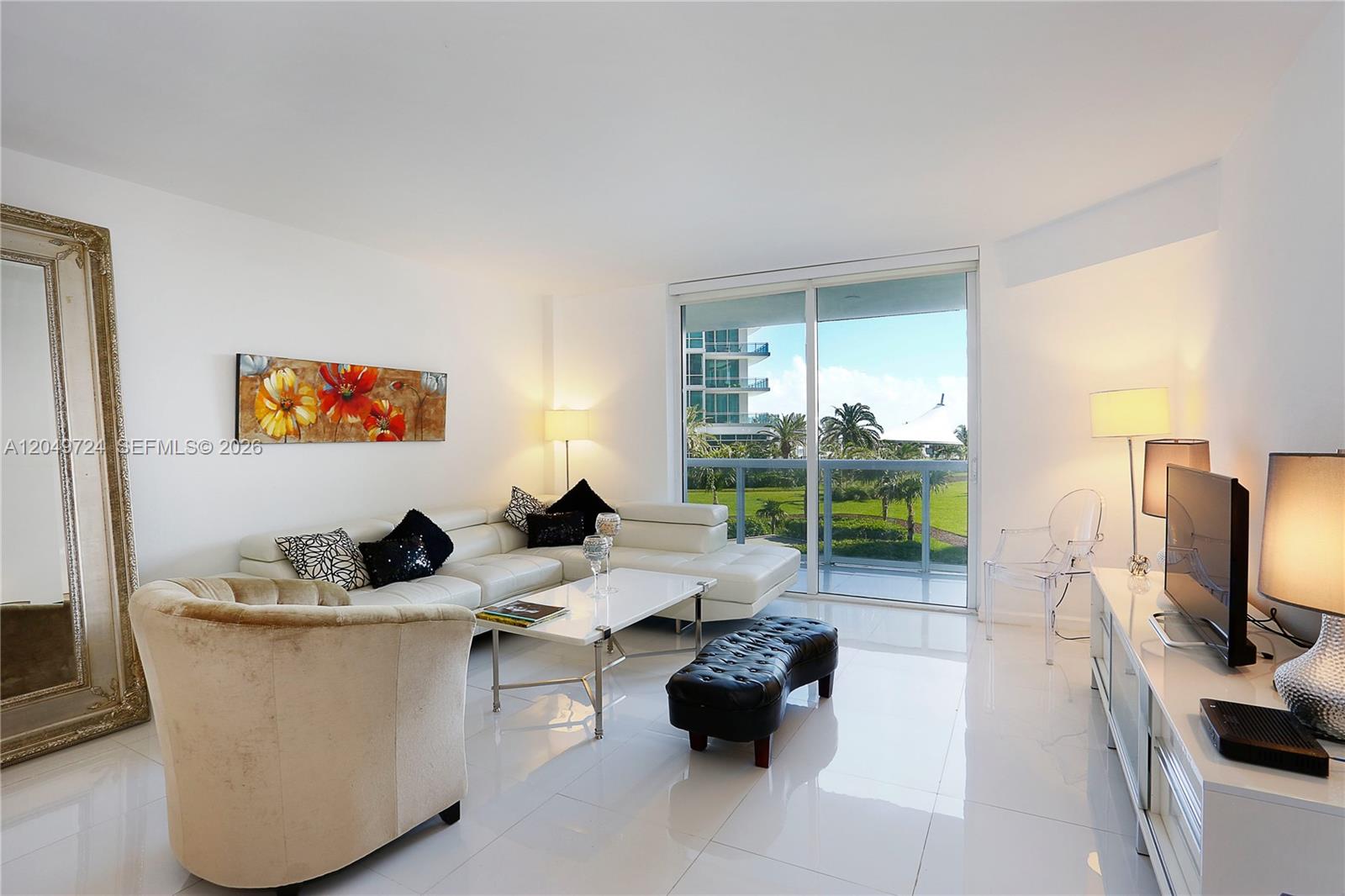A bright living room features white tile floors, a sectional sofa, and a balcony view — 10275 Collins Ave # 335, Bal Harbour FL 33154, BAL HARBOUR, FL
