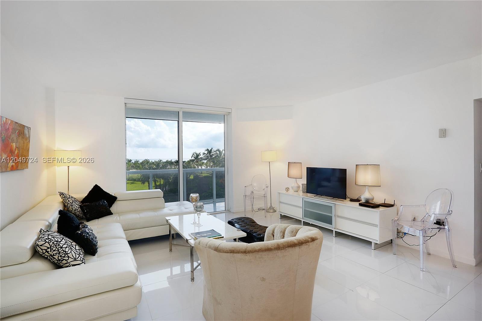 A living room features white tile floors, a white sectional sofa, and a balcony view — 10275 Collins Ave # 335, Bal Harbour FL 33154, BAL HARBOUR, FL