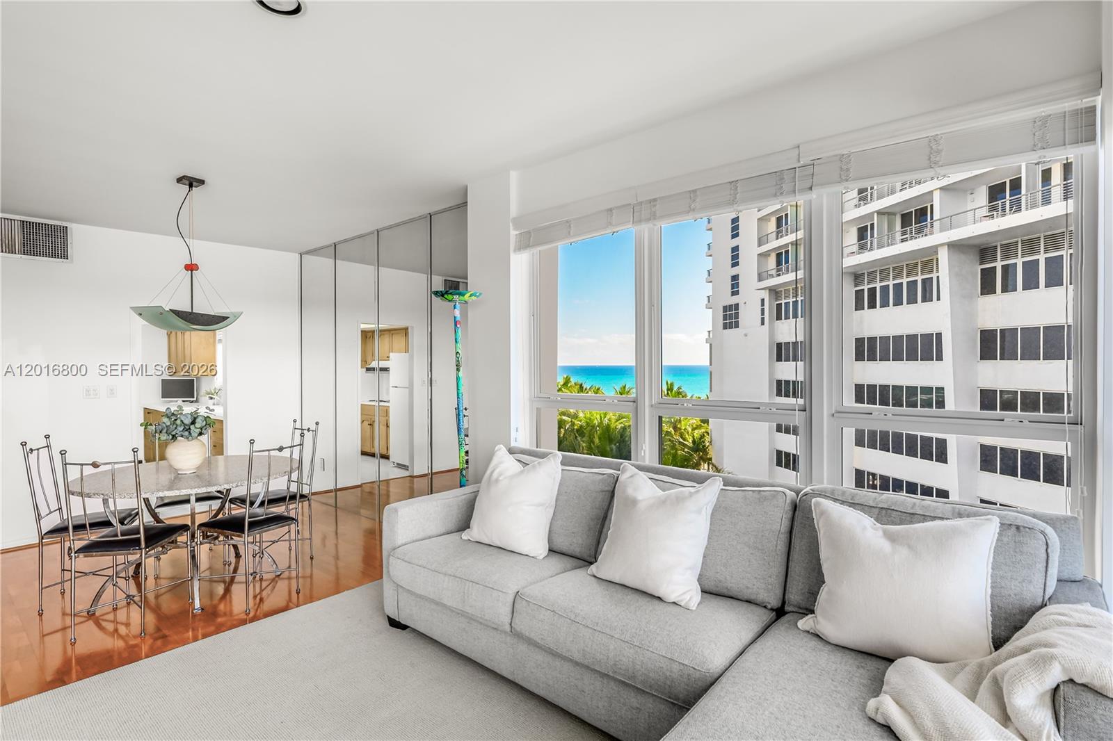 A living room with a gray sectional sofa, dining area, and ocean view windows — 4925 Collins Ave # 5F, Miami Beach FL 33140, MIAMI BEACH, FL