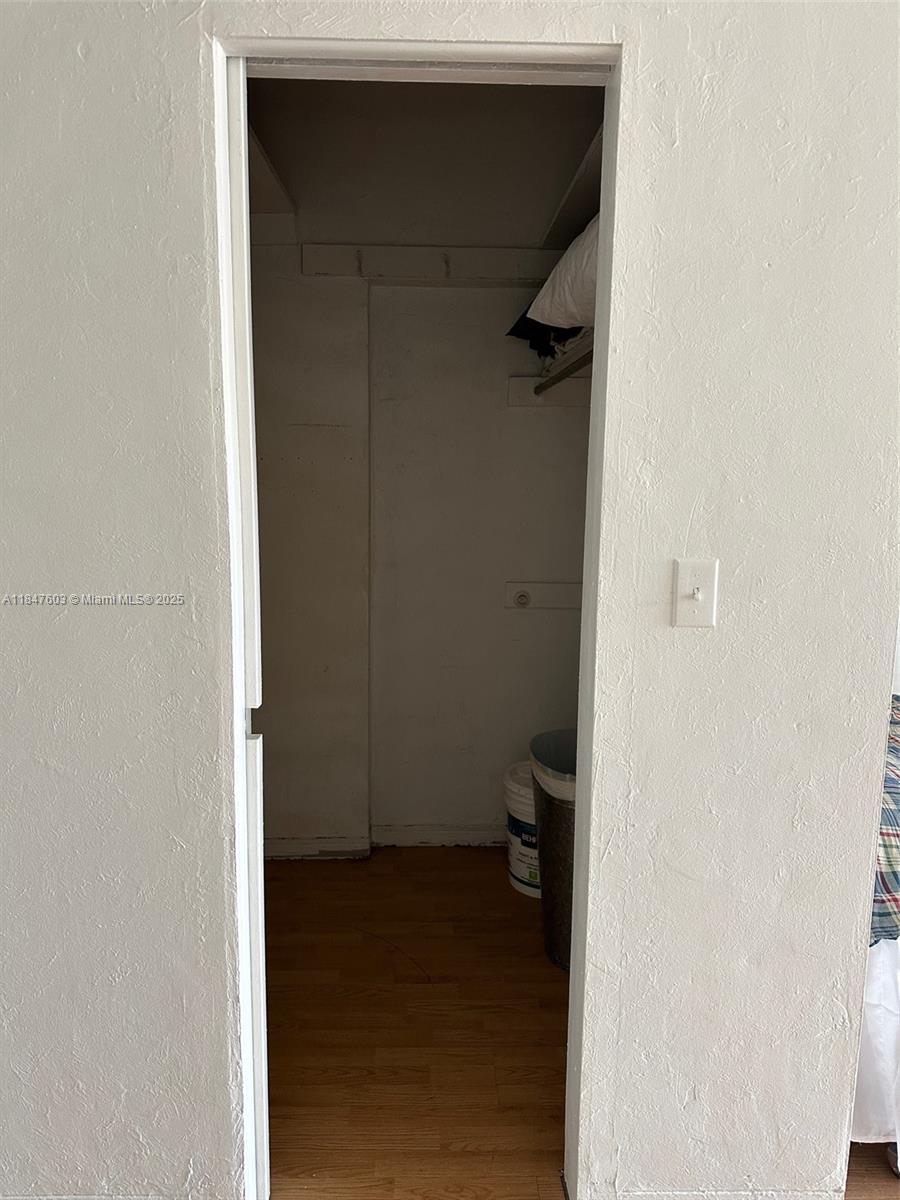 A small, empty closet features wood-look flooring, a single shelf, and white walls — 1400 Pennsylvania Ave # 33, Miami Beach FL 33139, MIAMI BEACH, FL