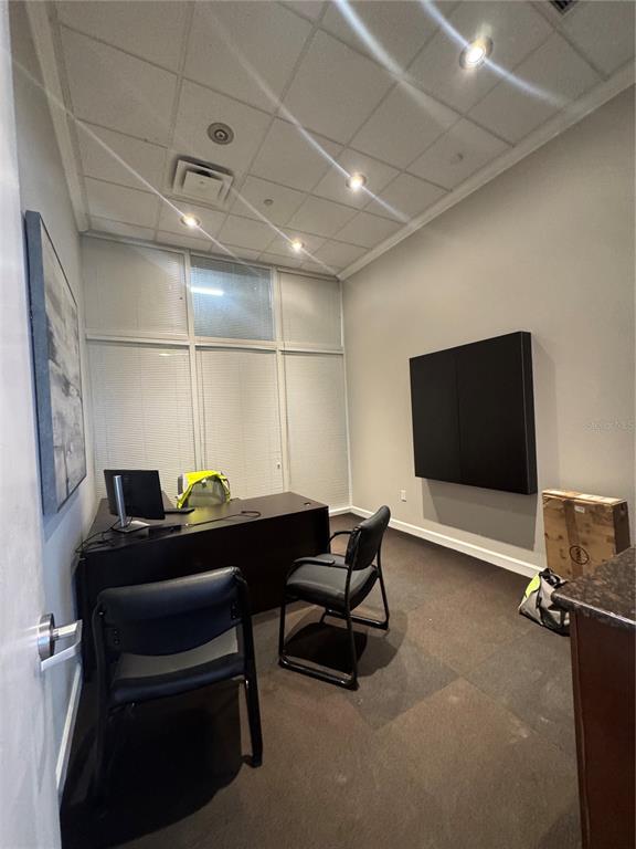 A small office features a dark desk, two black chairs, and large windows with blinds — 1112 CHANNELSIDE DRIVE UNIT CU6, TAMPA, FL