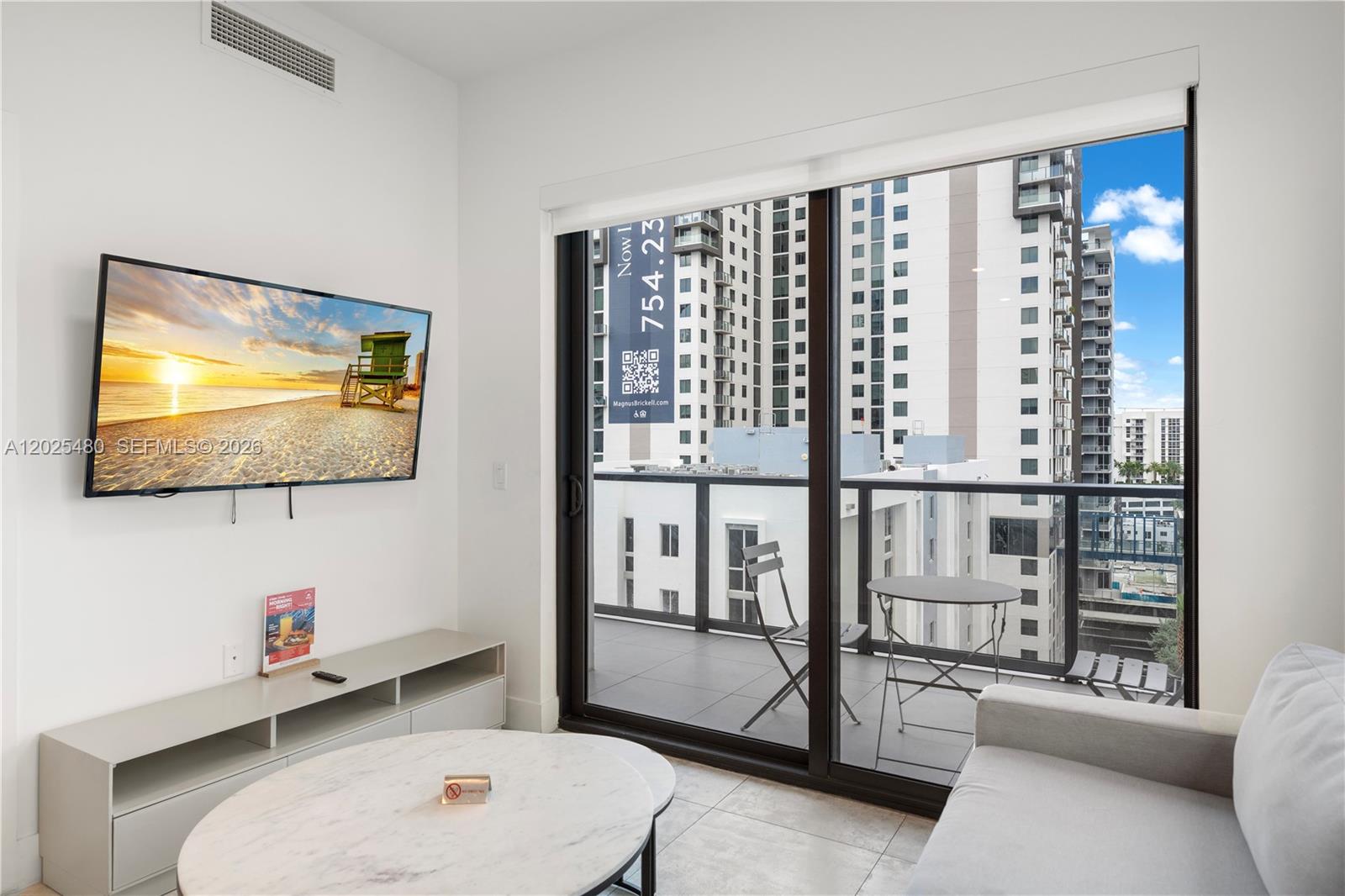 A modern living room features a wall-mounted television, a marble coffee table, and a balcony — 239 SW 9th St # 1202, Miami FL 33130, MIAMI, FL