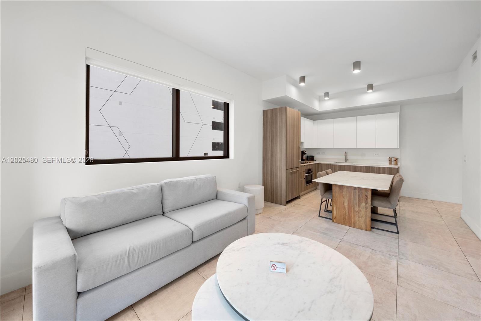 A modern living room and kitchen area features a light gray sofa, marble coffee table, and dining table — 239 SW 9th St # 1202, Miami FL 33130, MIAMI, FL