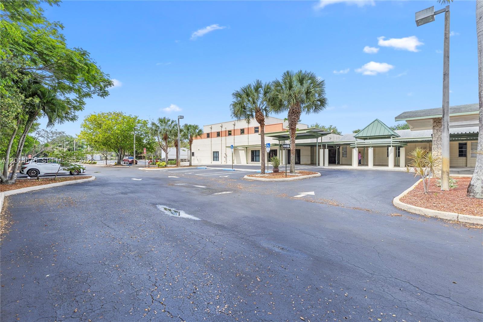 An exterior view of a commercial building with a parking lot and palm trees — 8530 Stirling Rd, Davie FL 33024, DAVIE, FL
