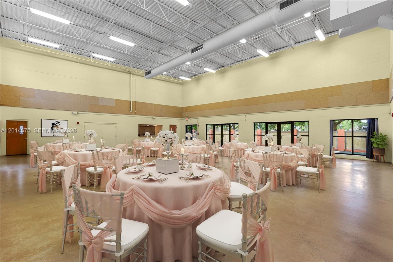 A large event hall features round tables with pink linens and white chairs — 8530 Stirling Rd, Davie FL 33024, DAVIE, FL