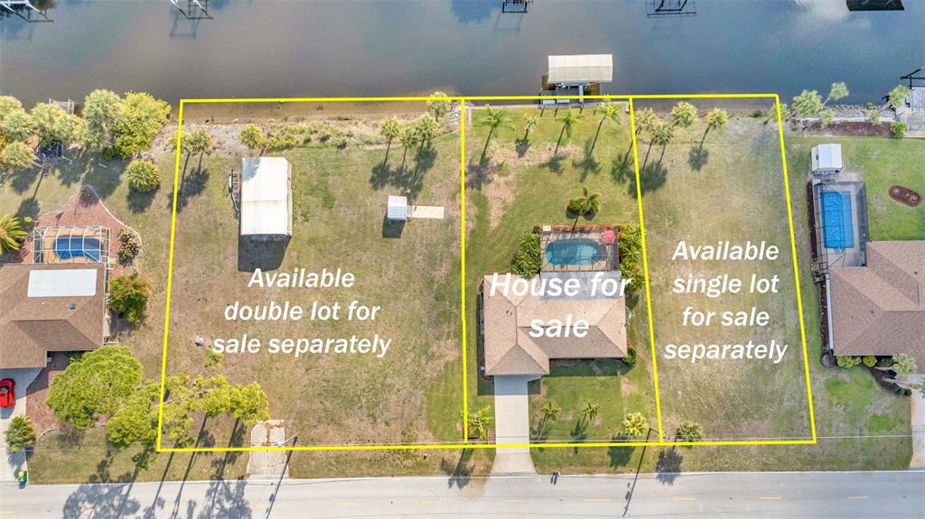 An aerial view shows a house and two adjacent vacant lots along a waterfront — 2410 /2418 COMO STREET, PORT CHARLOTTE, FL