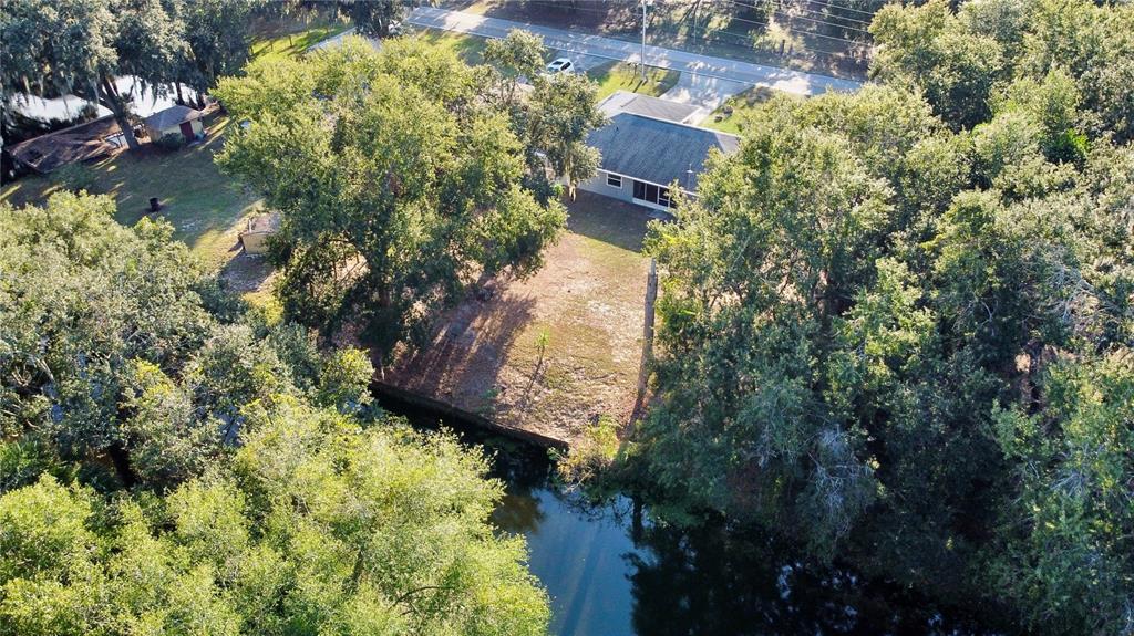 An aerial view shows a house with a screened porch situated on a wooded lot — 4542 TIMBERLANE ROAD, LAKE WALES, FL