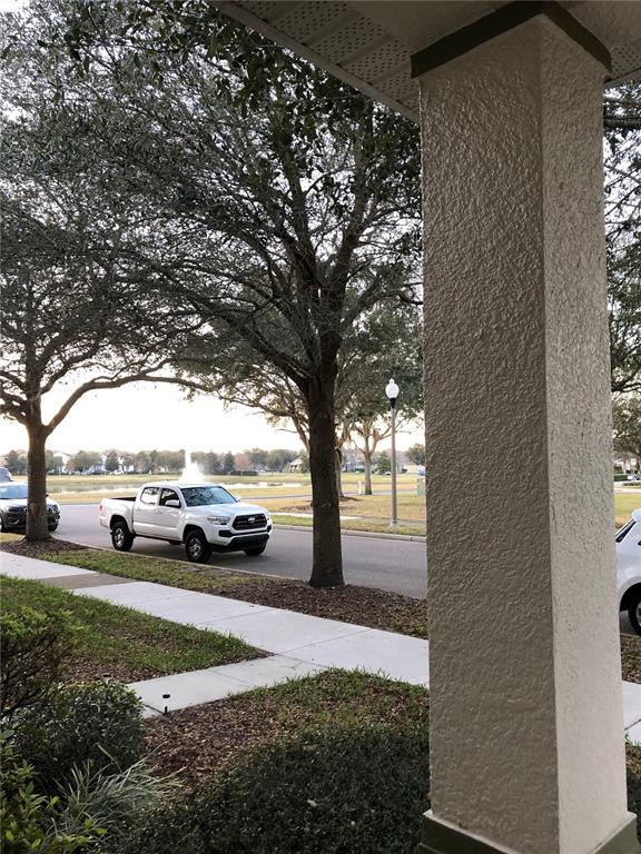 A view from a covered porch looking out at a street, trees, and a pickup truck — 12982 KEGAN STREET, WINDERMERE, FL
