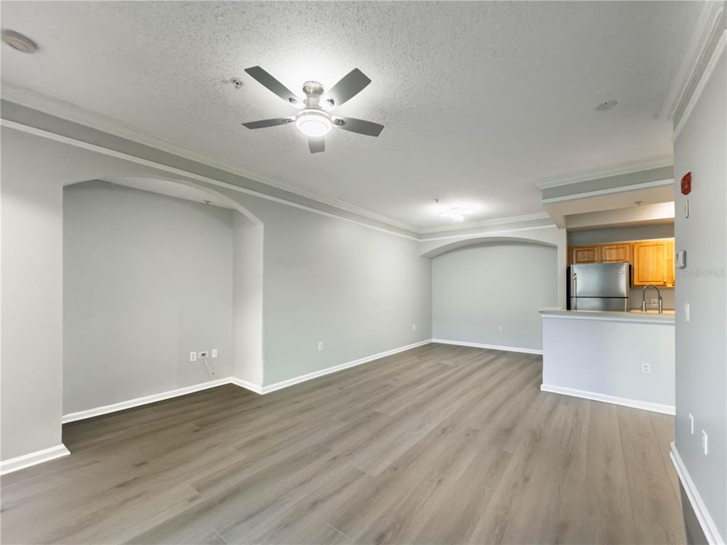 An open living area features light gray walls, wood-look flooring, and an arched wall niche — 12203 WILD IRIS WAY UNIT 108, ORLANDO, FL