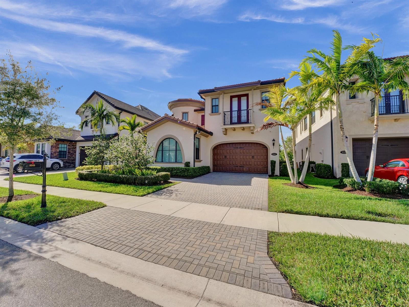 A two-story stucco house with a tiled roof, arched window, and paved driveway — 9345 Carrington Avenue, Parkland FL 33076, PARKLAND, FL