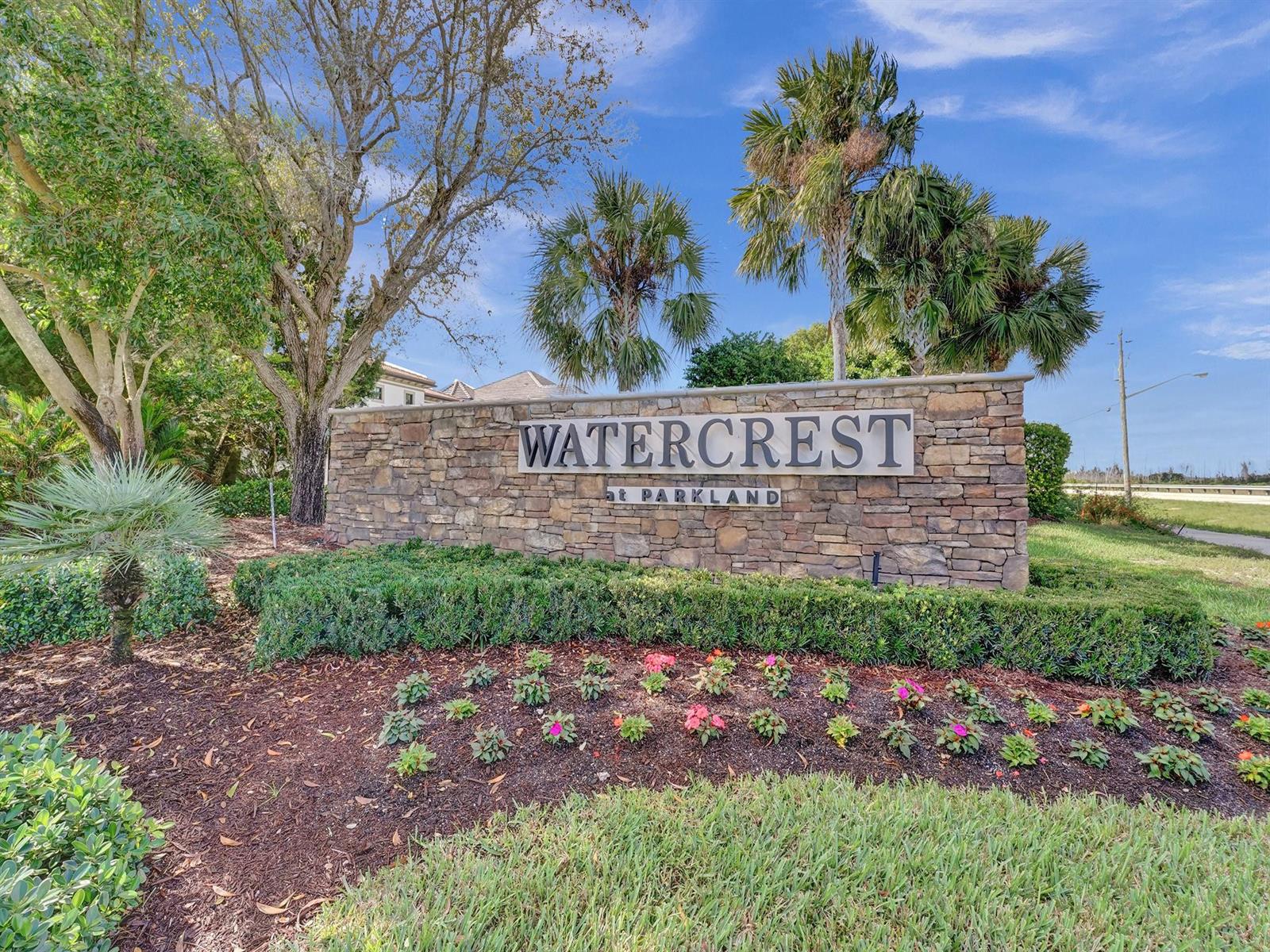 A stone monument sign for Watercrest at Parkland stands in a landscaped garden area — 9345 Carrington Avenue, Parkland FL 33076, PARKLAND, FL