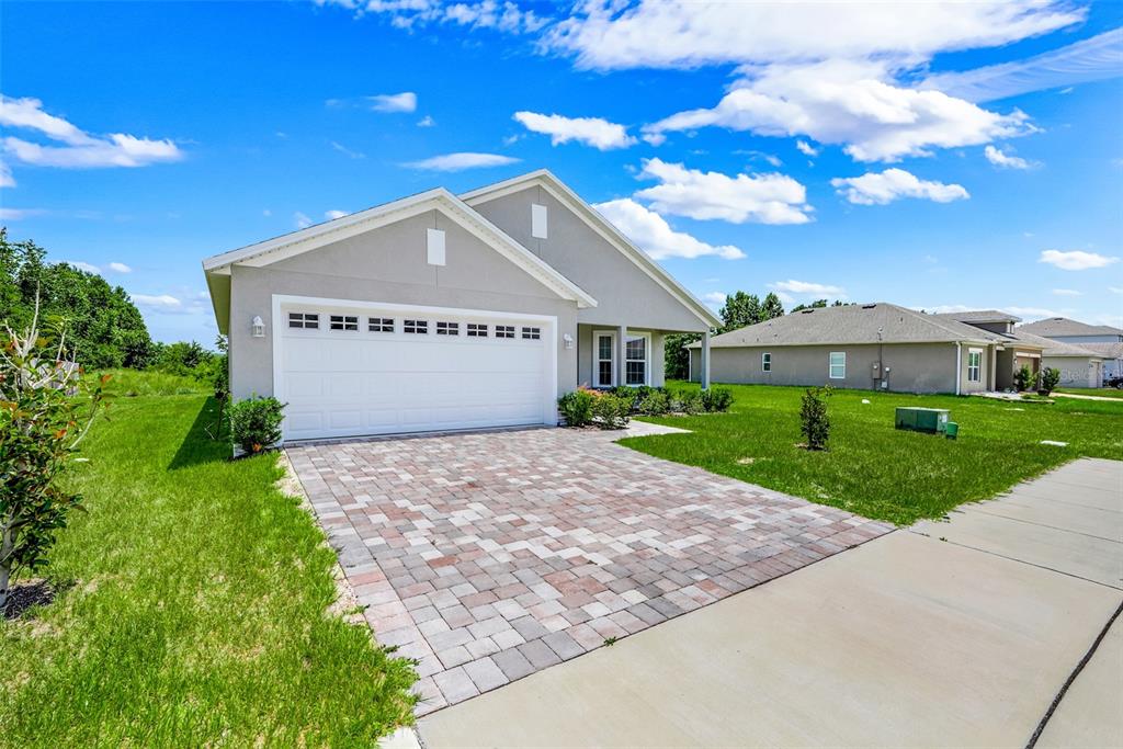 A single-story house with a gray exterior, a two-car garage, and a paved driveway — 3050 SUNSCAPE TERRACE, GROVELAND, FL