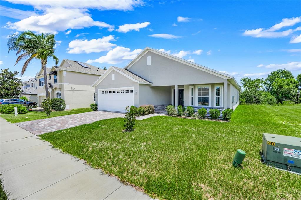 A single-story house with a white garage, gray exterior, and a paved driveway — 3050 SUNSCAPE TERRACE, GROVELAND, FL