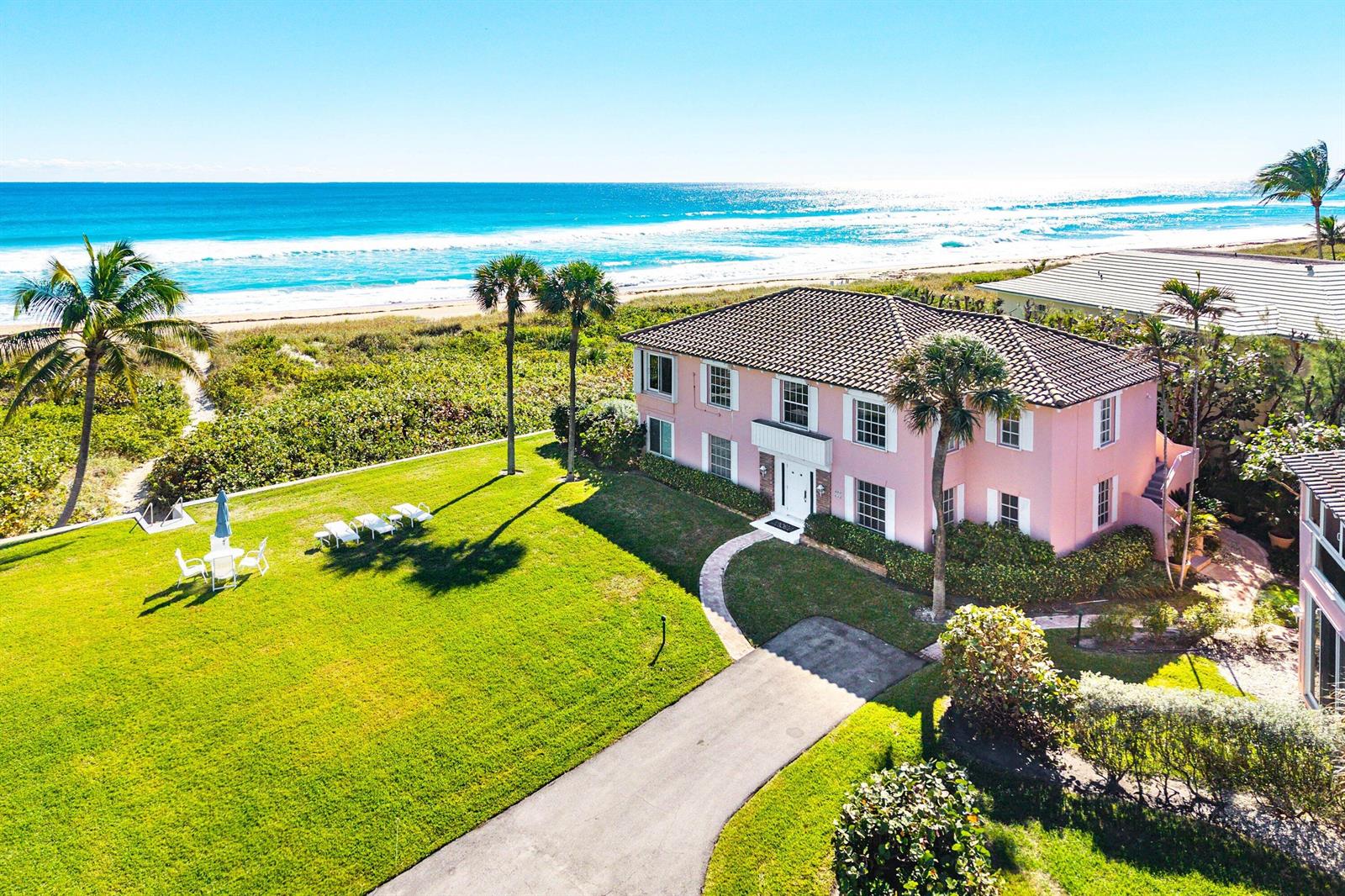An aerial view of a pink two-story house situated on a grassy lot by the ocean — 2075 S Ocean Boulevard # 4b, Delray Beach FL 33483, DELRAY BEACH, FL