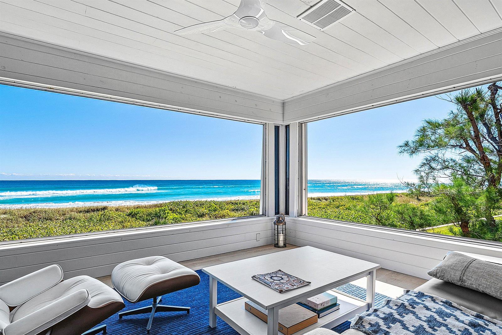 A sunroom with white walls and a ceiling fan overlooks the ocean through large windows — 2075 S Ocean Boulevard # 4b, Delray Beach FL 33483, DELRAY BEACH, FL
