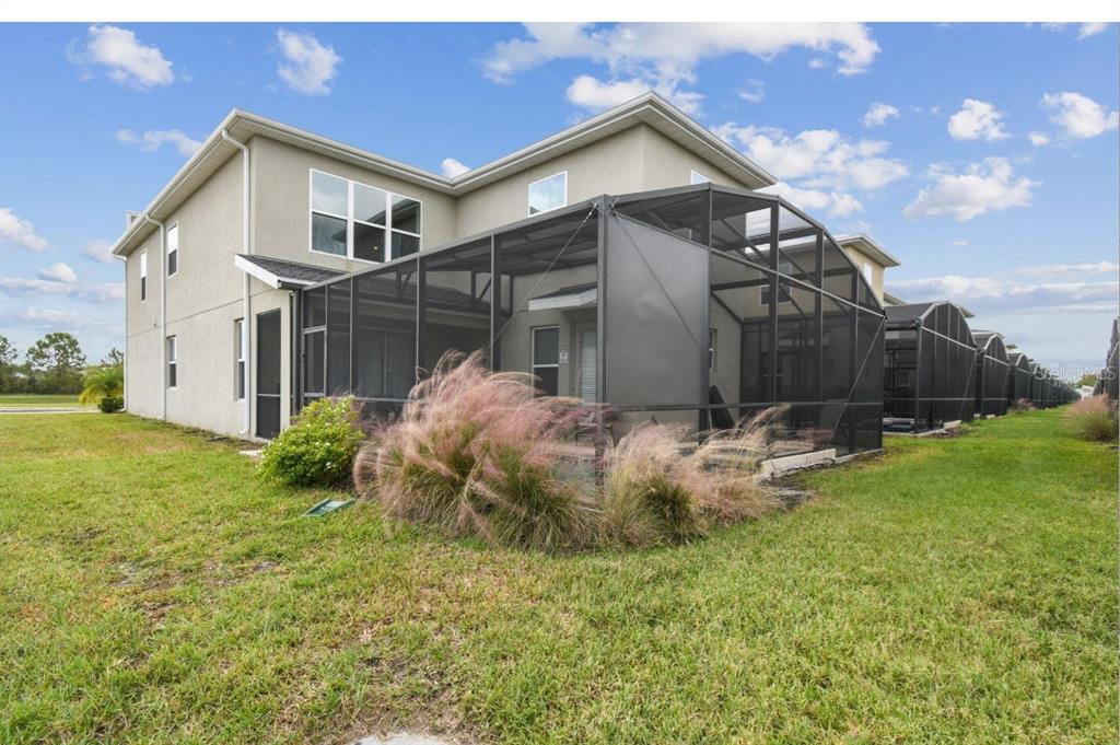 A two-story house with a screened-in patio and a grassy backyard — 2784 BOOKMARK DRIVE, KISSIMMEE, FL