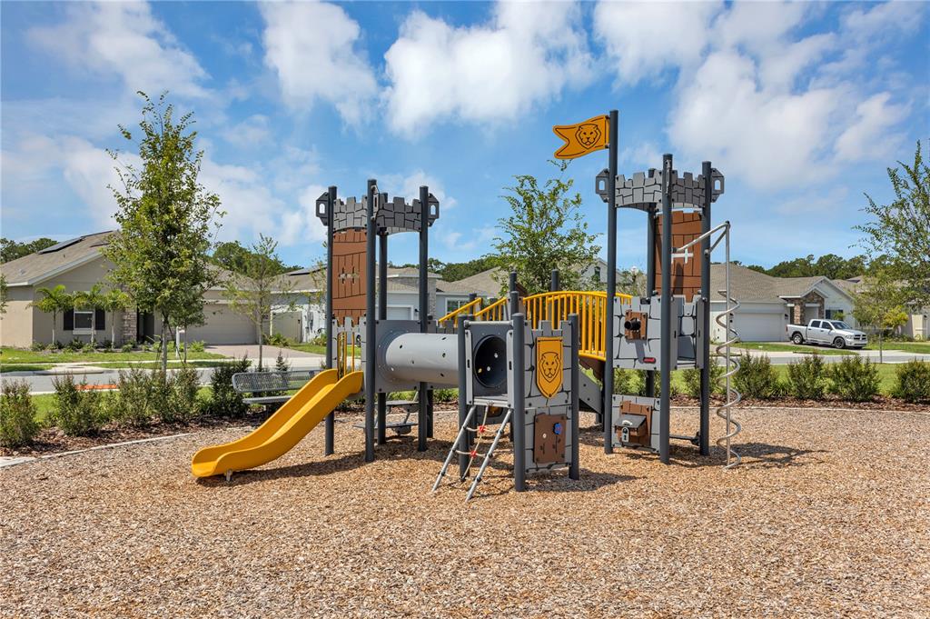 A castle-themed playground structure sits on a wood-chipped surface in a residential neighborhood — 3145 BROOKHOLLOW WAY, MINNEOLA, FL