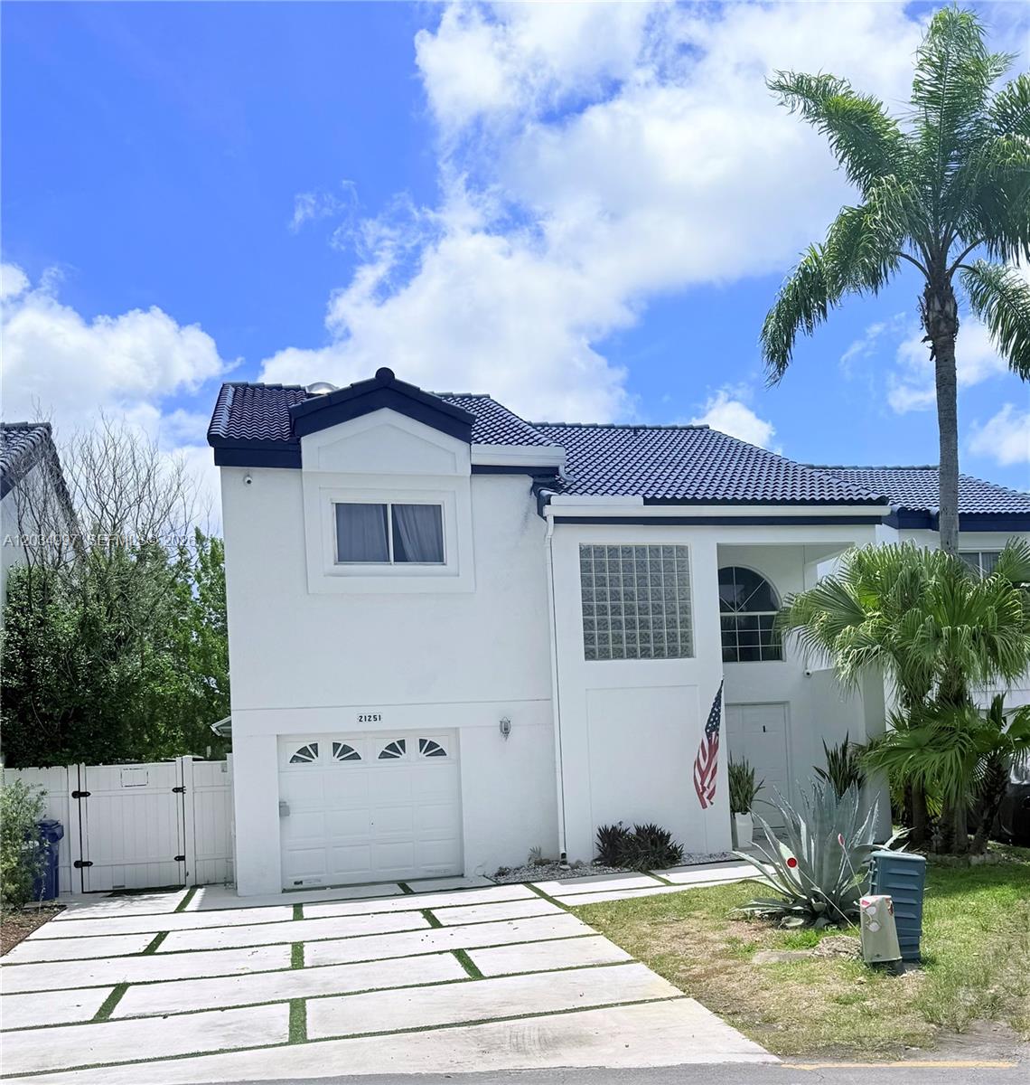 A two-story white house with a blue roof, a single-car garage, and a paved driveway — 21251 NE 3rd Ct, Miami FL 33179, MIAMI, FL