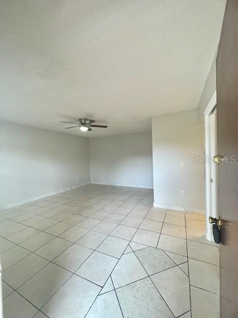 An empty room with light-colored tile flooring, white walls, and a ceiling fan — 730 WYMAN COURT UNIT 730, ORLANDO, FL