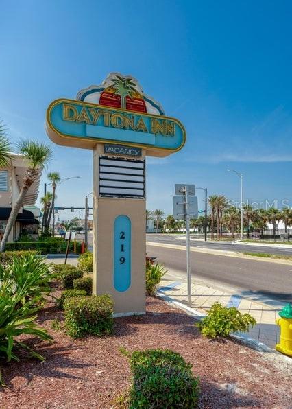 A bedroom features a bed, a gray sofa, and blue walls decorated with surfboard accents — 219 S ATLANTIC AVENUE UNIT 403, DAYTONA BEACH, FL
