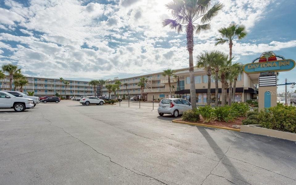 A bedroom features a king bed, blue walls with surfboard decor, and a small dining area — 219 S ATLANTIC AVENUE UNIT 403, DAYTONA BEACH, FL