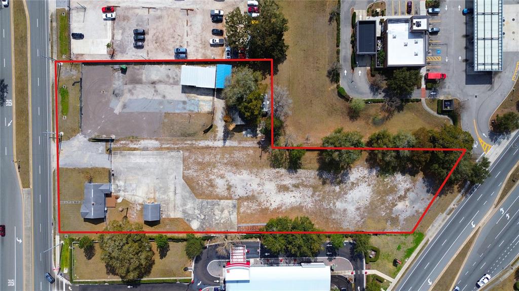 An aerial view shows a commercial property outlined in red with paved and gravel areas — 4604 OLD GOLDENROD ROAD, ORLANDO, FL