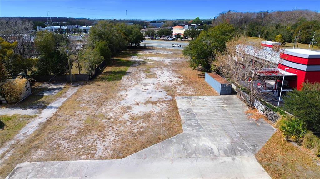 An aerial view shows a vacant, rectangular dirt lot adjacent to a commercial building — 4604 OLD GOLDENROD ROAD, ORLANDO, FL