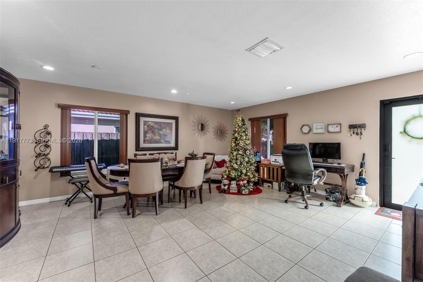 A dining room with tile floors, a Christmas tree, and a desk area — 11347 SW 246th Ter, Homestead FL 33032, HOMESTEAD, FL