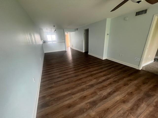 An open-concept living area features light blue walls and dark wood-look laminate flooring — 211 S 6TH STREET UNIT 504, COCOA BEACH, FL