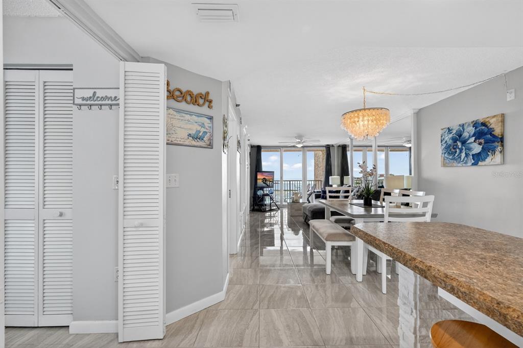 A view from a kitchen looking toward a dining area and a balcony with water views — 421 S ATLANTIC AVENUE UNIT 409, NEW SMYRNA BEACH, FL