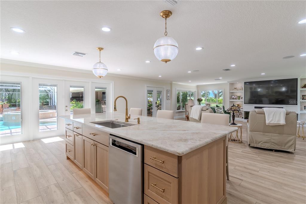 A kitchen island with a sink and light wood cabinets sits in an open-concept living space — 8010 LAKE LOWERY ROAD, HAINES CITY, FL