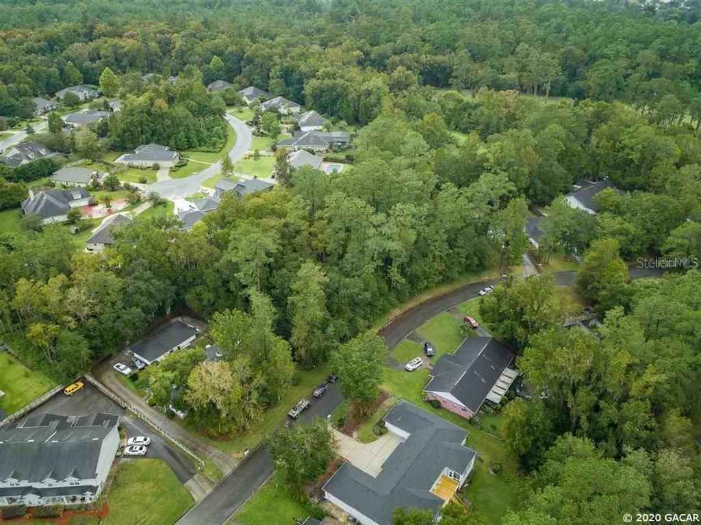 An aerial view shows suburban houses nestled among dense trees and winding roads — 2804 NW 104TH COURT, GAINESVILLE, FL
