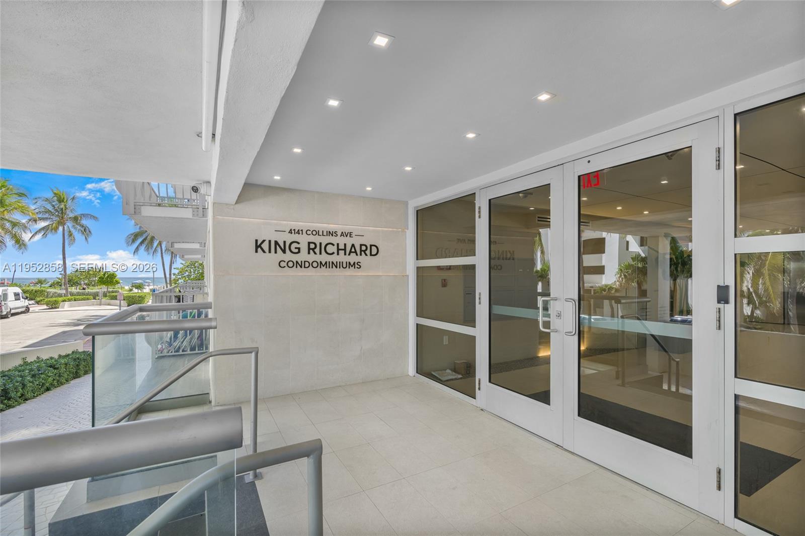 The entrance to a condominium building features glass doors, recessed lighting, and a stone wall — 4141 Collins Ave # 201, Miami Beach FL 33140, MIAMI BEACH, FL