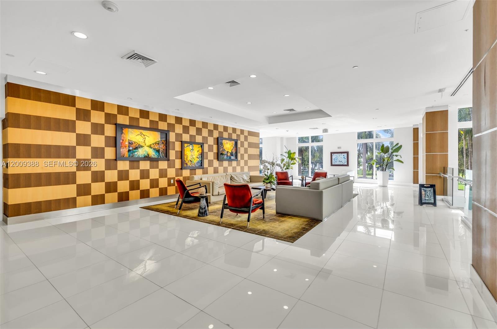 A modern lobby features a checkered wood accent wall, white tile floors, and seating areas — 1800 N Bayshore Dr # 4208, Miami FL 33132, MIAMI, FL