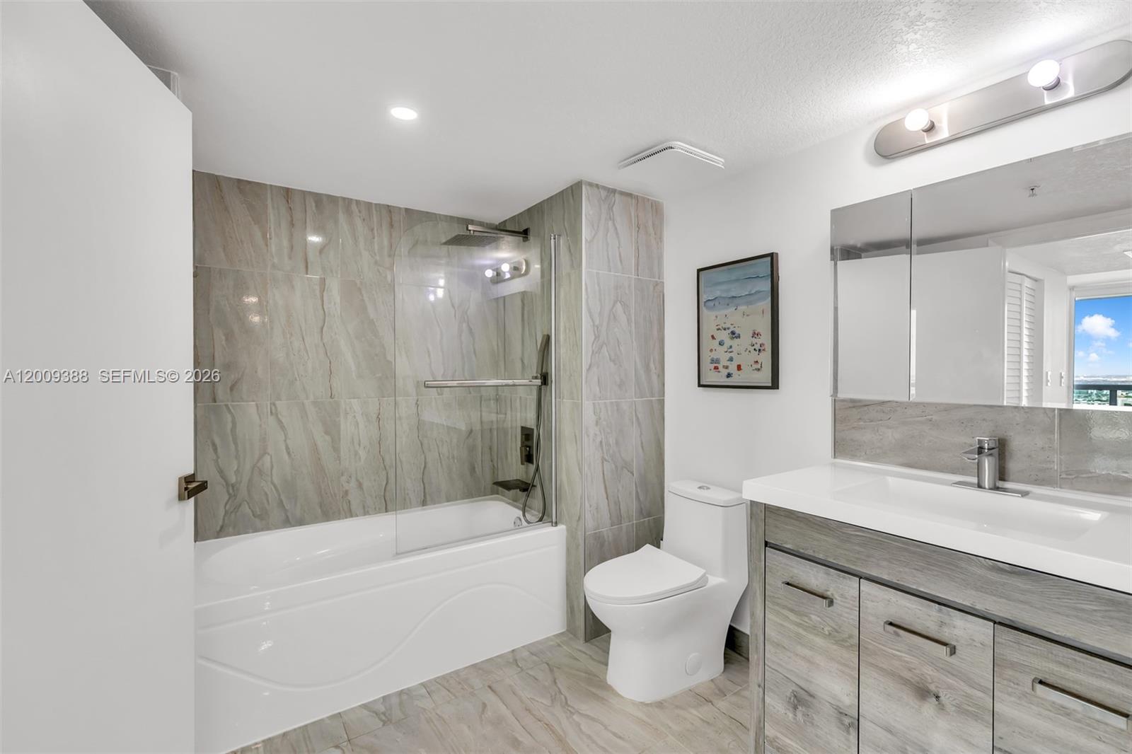 A bathroom features a tiled bathtub shower combo, a white toilet, and a wood-grain vanity — 1800 N Bayshore Dr # 4208, Miami FL 33132, MIAMI, FL
