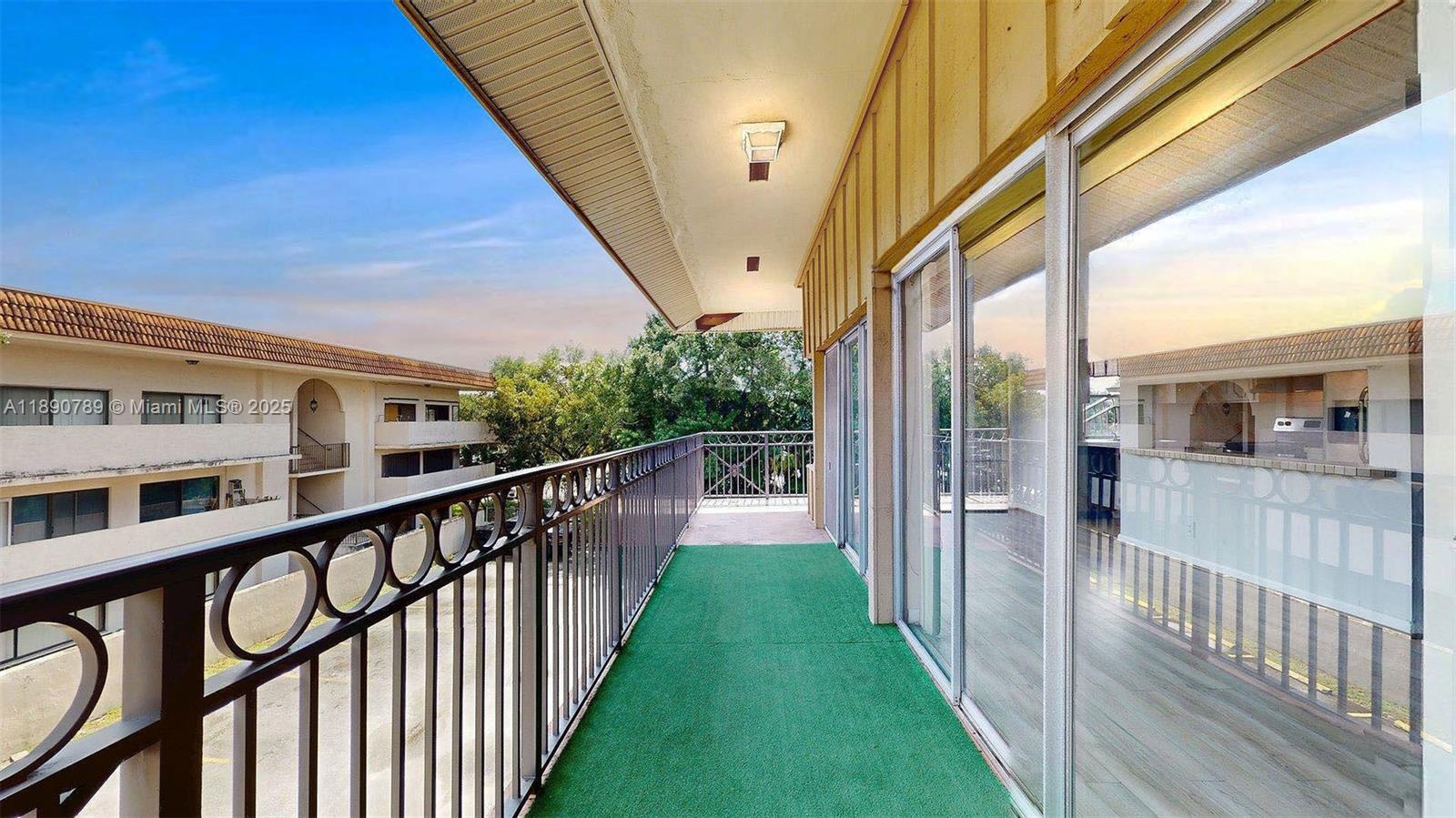 A balcony with green outdoor carpeting, a metal railing, and sliding glass doors — 4850 SW 63rd Ter # 131, Davie FL 33314, DAVIE, FL