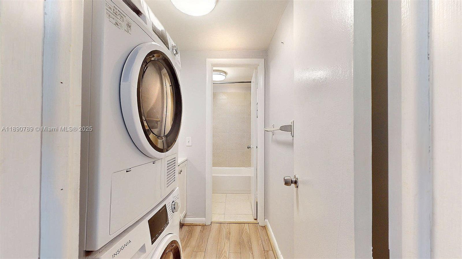A laundry closet with a stacked washer and dryer leads into a tiled bathroom — 4850 SW 63rd Ter # 131, Davie FL 33314, DAVIE, FL