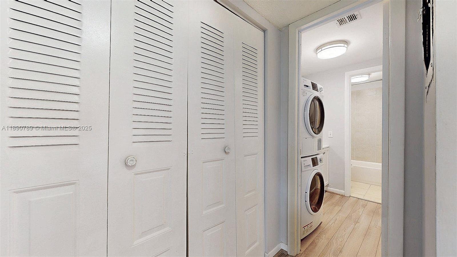 A hallway features louvered closet doors and a stacked washer and dryer unit — 4850 SW 63rd Ter # 131, Davie FL 33314, DAVIE, FL