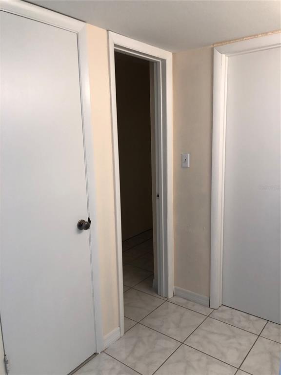 A hallway features white doors, light-colored tile flooring, and a central open doorway — 2616 LEMON TREE LANE UNIT F, ORLANDO, FL