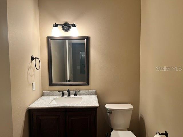 A bathroom features a dark wood vanity, a framed mirror, and a toilet — 421 E PARK STREET, LAKELAND, FL