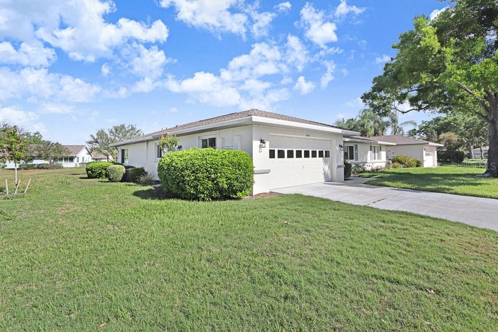 A single-story house with a white exterior, a two-car garage, and a manicured lawn — 2306 LANCASTER DRIVE UNIT 2306, SUN CITY CENTER, FL